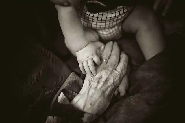 Baby holding elderly hand
